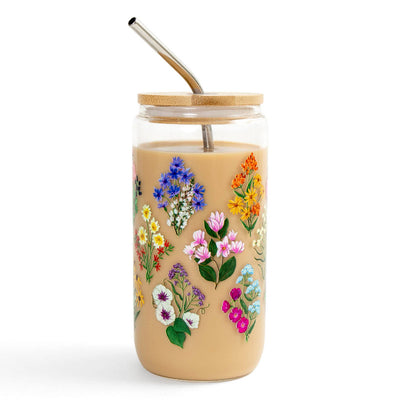 Glass tumbler with floral designs and a bamboo lid on a white background