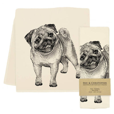Two cream-colored tea towels with black line art illustrations of a pug dog, shown on a white background. One towel is displayed flat, and the other is folded with a paper band label that reads 'ERIC & CHRISTOPHER TEA TOWEL'.