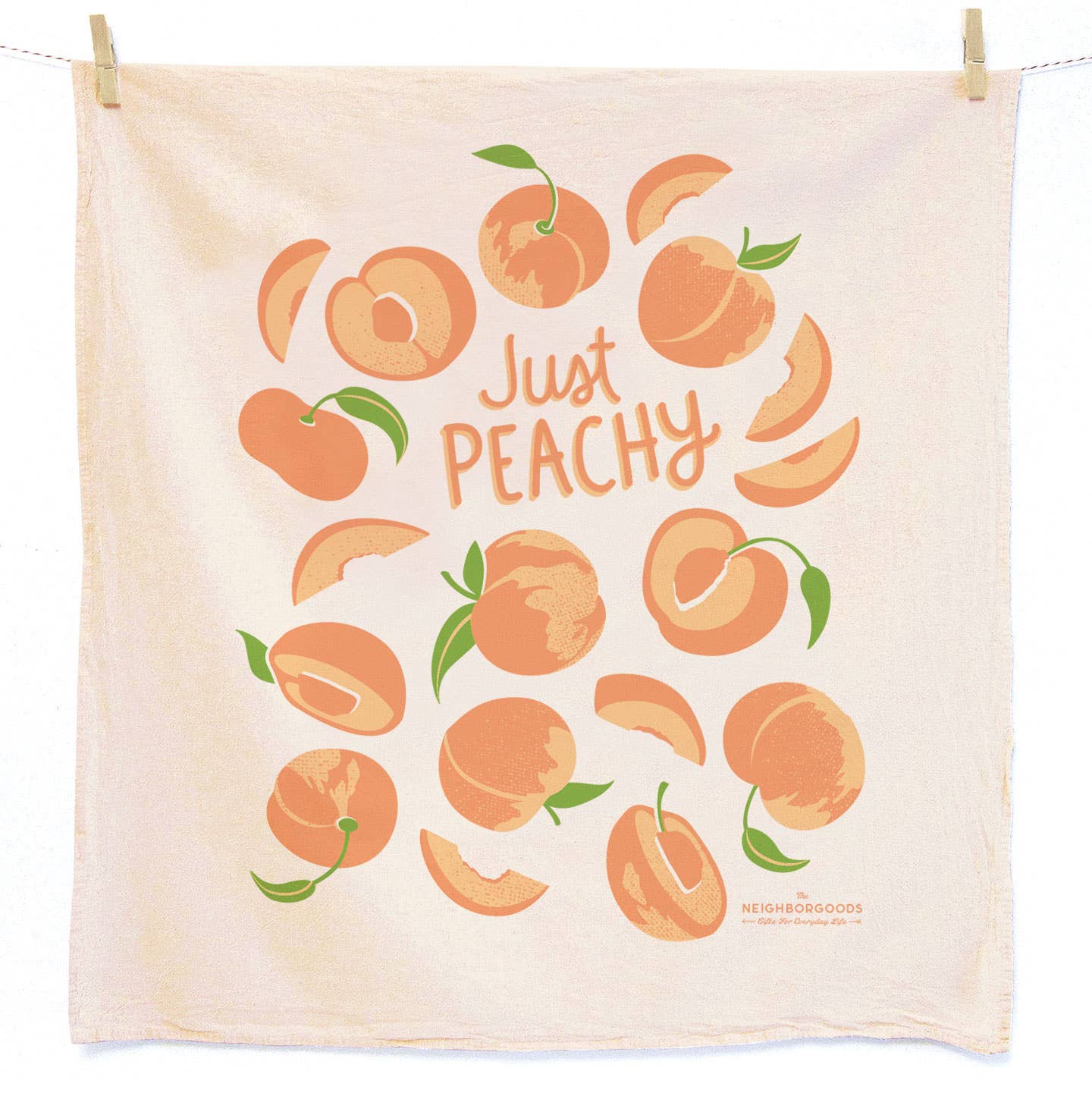 A square beige tea towel with a peach-themed graphic print reading 'Just PEACHY' in orange script, surrounded by illustrated peaches and peach slices. The towel is clipped to a white hanging line against a white background.