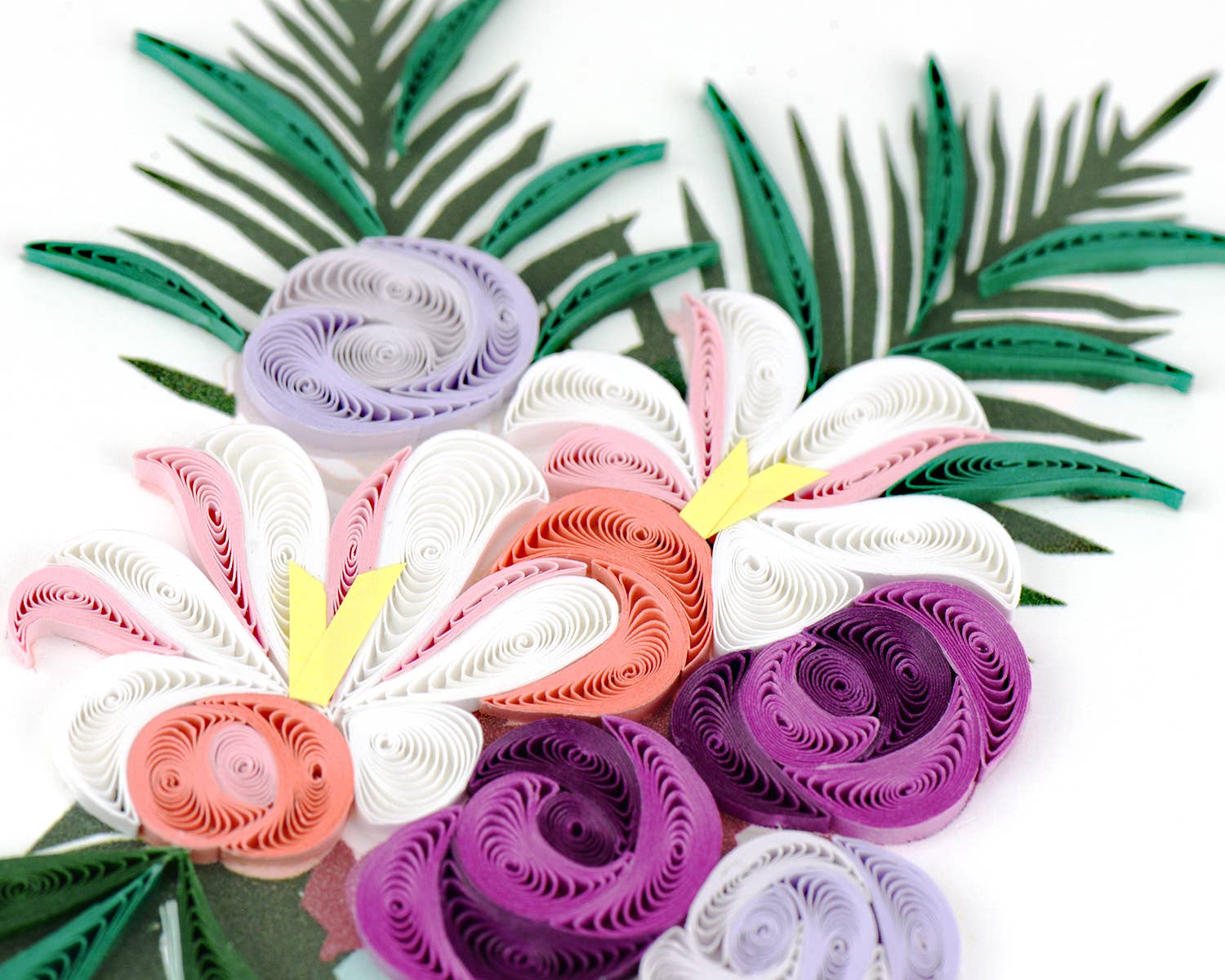 Colorful paper flowers with green leaves on a white background