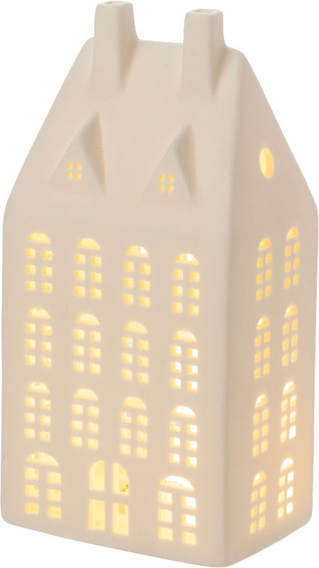 Ceramic house-shaped lantern with lit interior on a white background